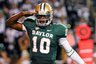FILE - In this Oct. 8, 2011, file photo Baylor quarterback Robert Griffin III salutes after throwing a touchdown pass to wide receiver Kendall Wright during an NCAA college football game in Waco, Texas. A person familiar with the decision says Heisman Trophy winner Griffin has decided to enter the NFL draft. ESPN, citing an anonymous family source, first reported that Griffin is going pro and is in the final stages of picking an agent. (AP Photo/Waco Tribune-Herald, Jerry Larson, File)